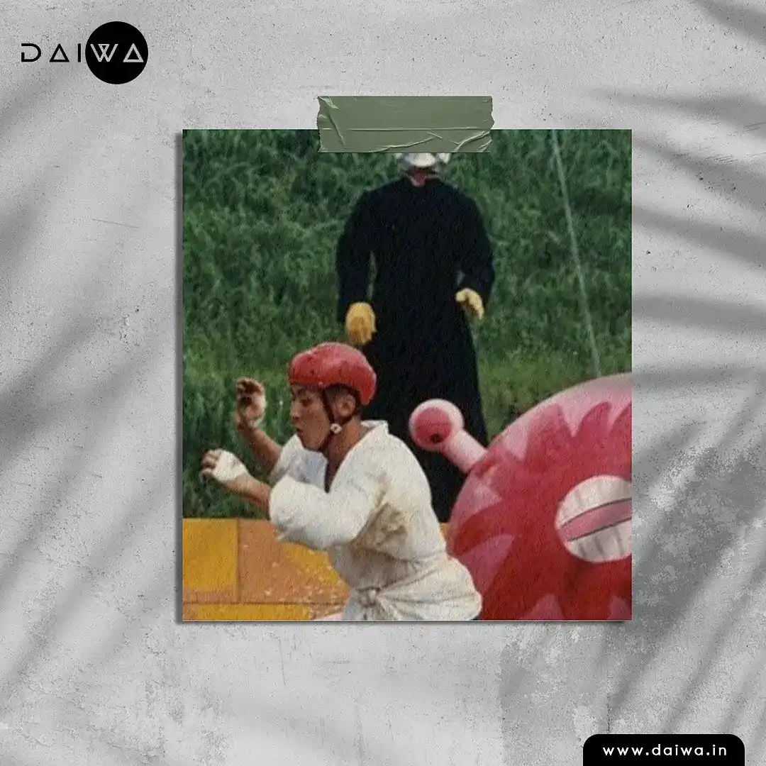 Taped-on photo of a runner in a red helmet and white robe running past a giant pink inflatable, a robed figure behind