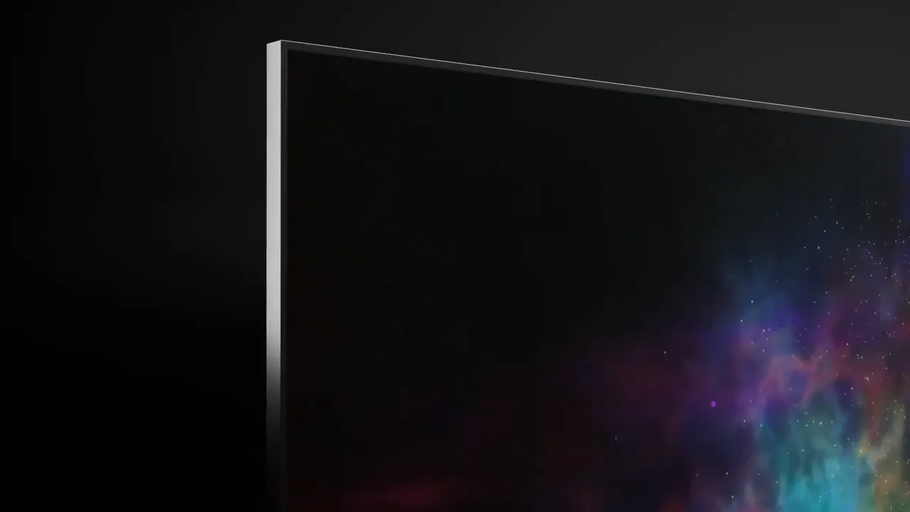 Dark close-up of a thin-bezel TV corner, with a purple, teal and orange nebula glowing at the screen's edge