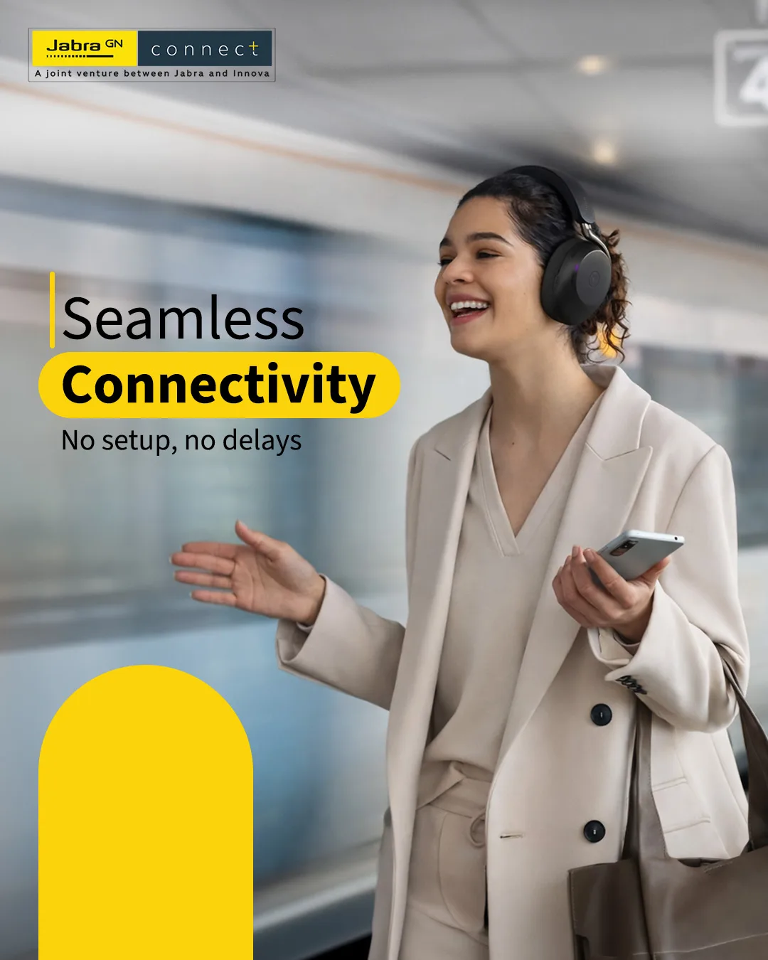 Smiling woman in headphones and a cream coat holding a phone on a station platform, train blurred behind, headline Seamless Connectivity
