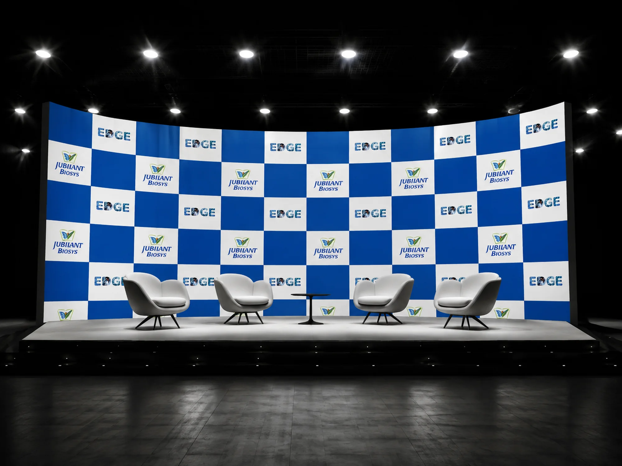 Jubilant Biosys EDGE step-and-repeat stage backdrop behind a four-chair panel set