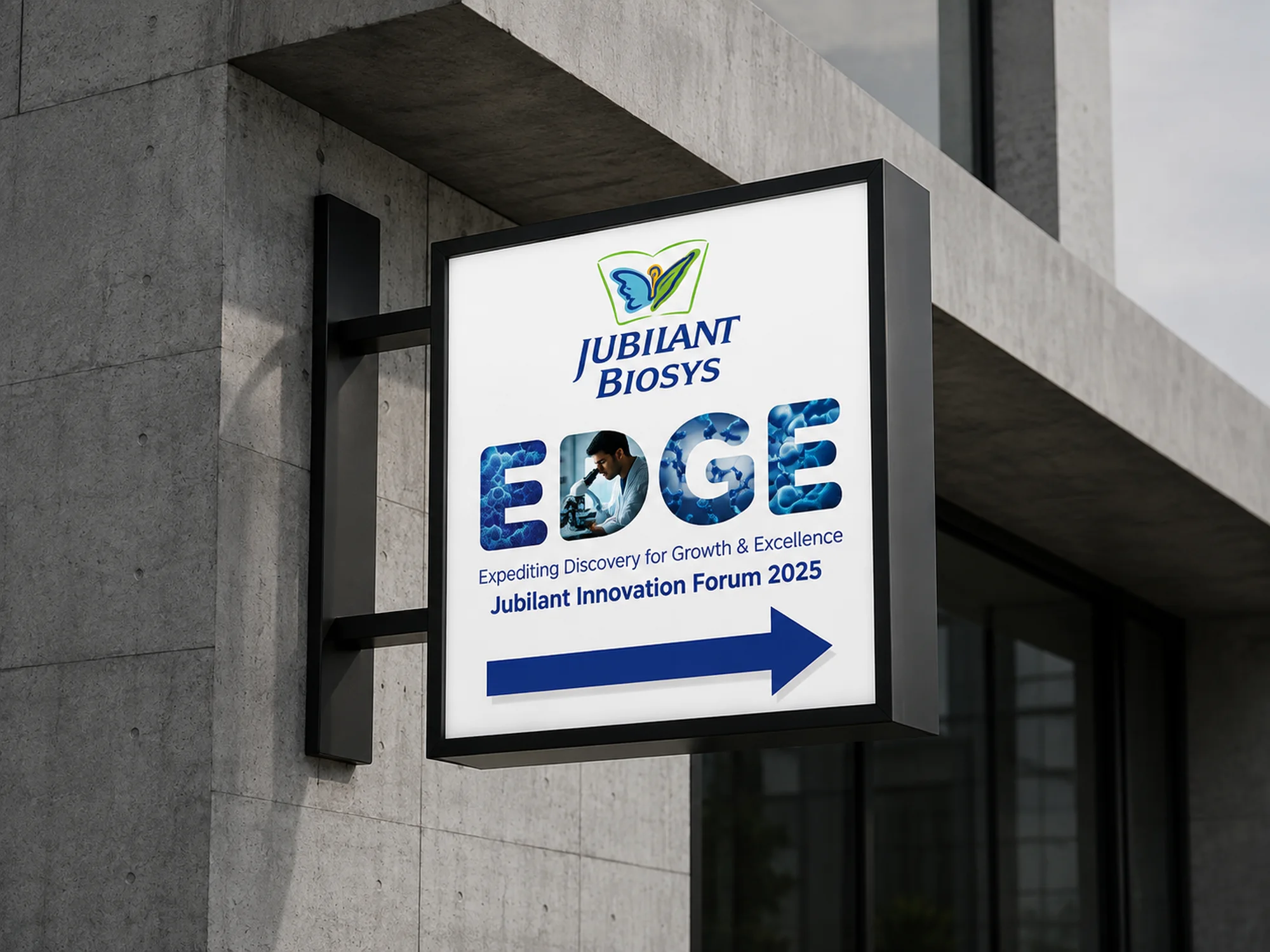 Jubilant Biosys EDGE illuminated blade sign mounted on a concrete building facade